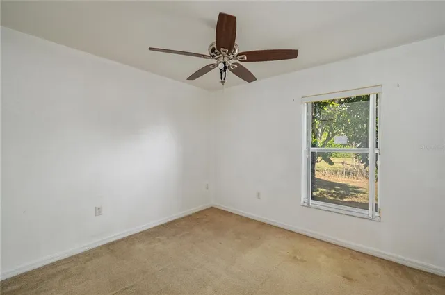 an empty room with window and fan