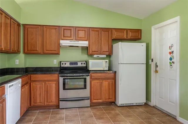 a kitchen with a refrigerator sink and cabinets