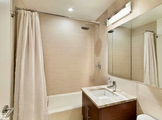 a bedroom with a bed lamp and a large window