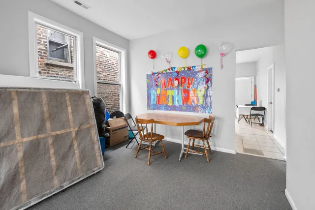 a living room with furniture and a baby crib next to a window