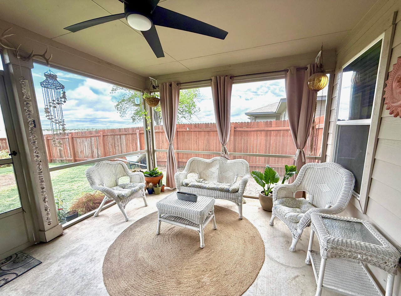 930 Pumpkin Ridge New Braunfels, TX 78130 - Photo 2 of 32 Screened porch featuring a ceiling fan, concrete flooring, and a private perimeter fence