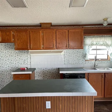 a kitchen with stainless steel appliances granite countertop a sink a stove cabinets and wooden floor