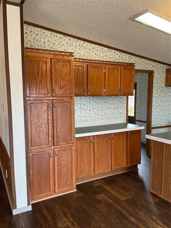 a view of a kitchen with wooden floor and a window