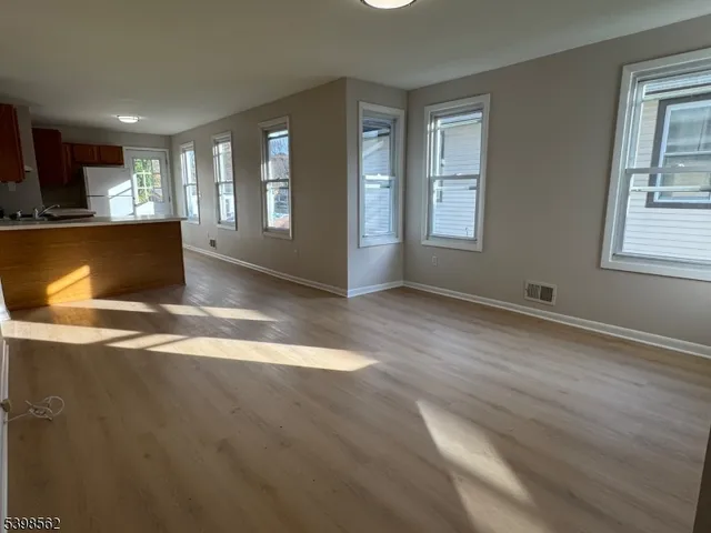 a view of kitchen and hall with wooden floor
