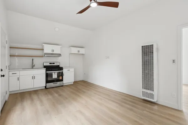a view of a room with wooden floor ceiling fan