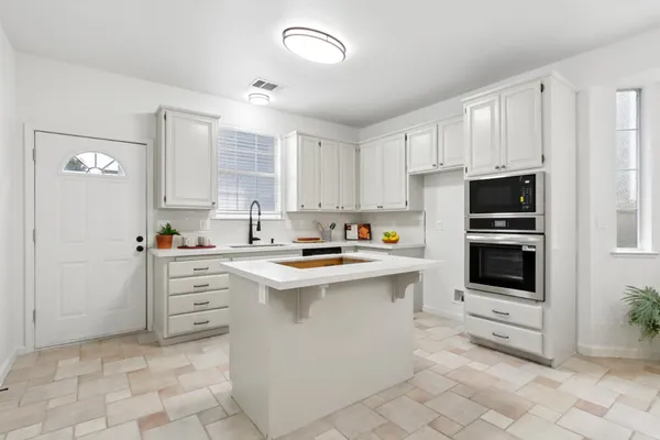 a kitchen with stainless steel appliances a stove sink and microwave