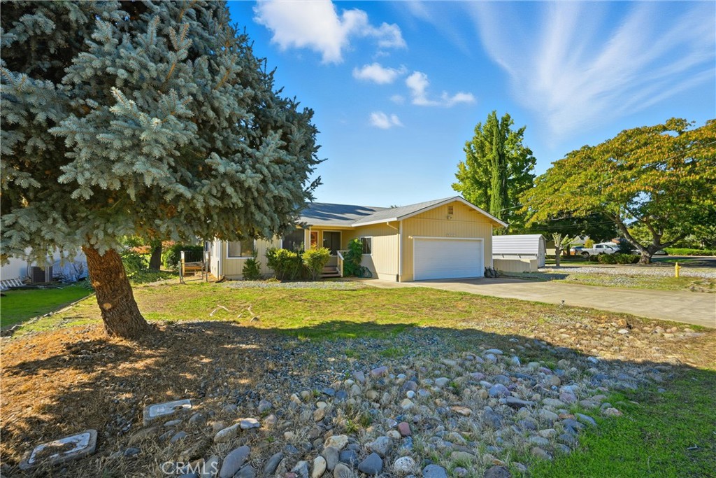 a front view of a house with a yard and trees