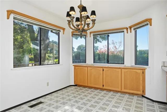 a view of an empty room with a window and a chandelier
