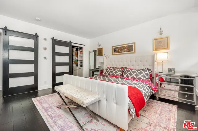 a bedroom with a bed and flat screen tv