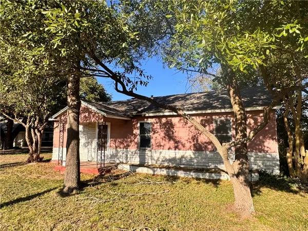 a front view of a house with a tree