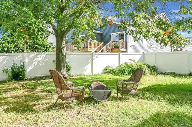 a view of a chair and table in backyard of the house