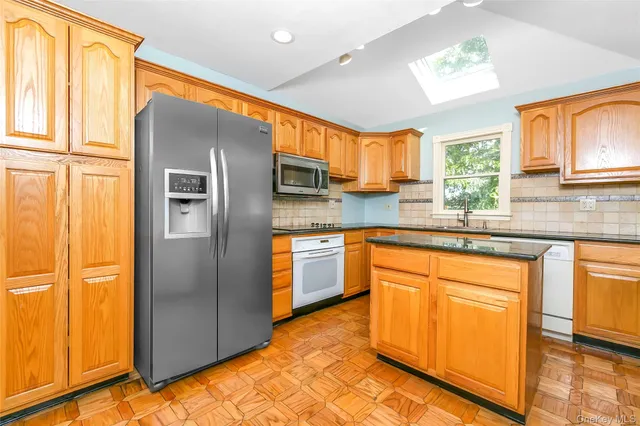 a kitchen with stainless steel appliances granite countertop a refrigerator and a sink