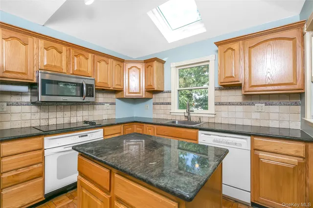 a kitchen with stainless steel appliances granite countertop wooden cabinets a sink and a stove