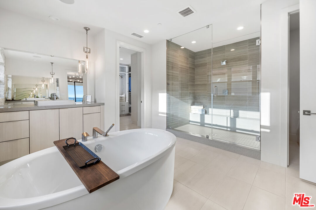 20378 Marlow Lane Porter Ranch, CA 91326 - Photo 20 of 52 a bathroom with a tub a double vanity sink a mirror and a shower