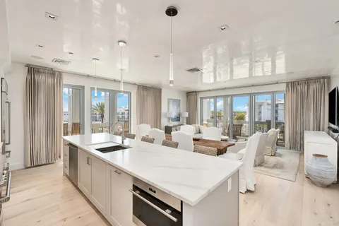 a large white kitchen with a large window and stainless steel appliances