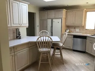 a kitchen with stainless steel appliances granite countertop a sink a stove a dining table and chairs