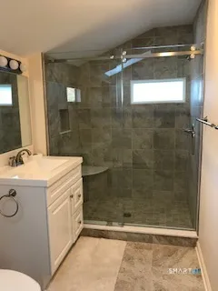 a bathroom with a granite countertop sink a toilet and shower