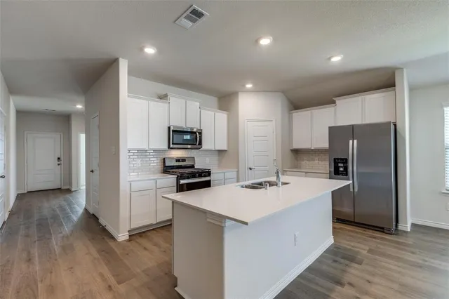 a kitchen with stainless steel appliances a refrigerator stove microwave and cabinets