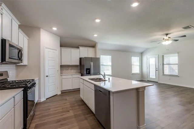 a kitchen with stainless steel appliances granite countertop a sink stove oven and refrigerator