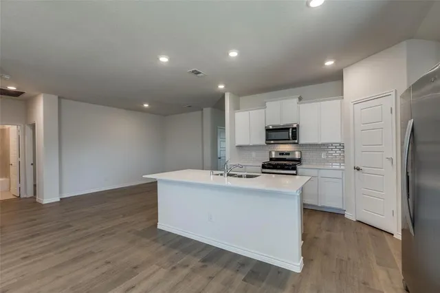 a kitchen with a refrigerator and a stove top oven