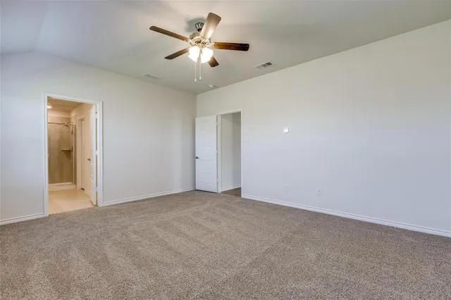 an empty room with a ceiling fan and a window