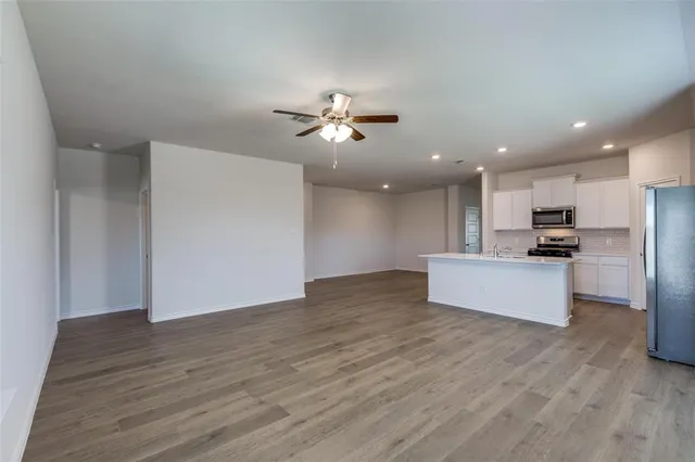a view of kitchen with refrigerator stove and wooden floor