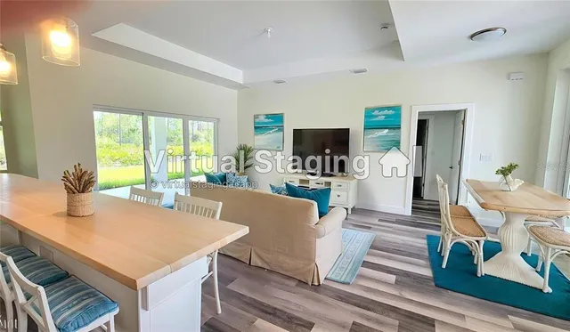 a living room with furniture a flat screen tv and a large window