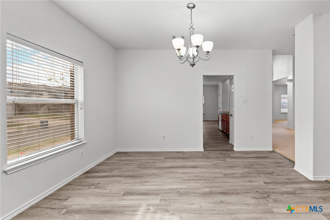 6700 Tulloch Way Austin, TX 78754 - Photo 7 of 41 a view of an empty room with wooden floor and a window