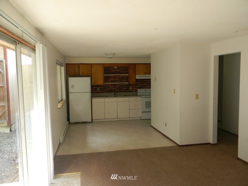 513 Roe Street Steilacoom, WA 98388 - Photo 7 of 14 a view of a kitchen with a refrigerator a microwave and a sink