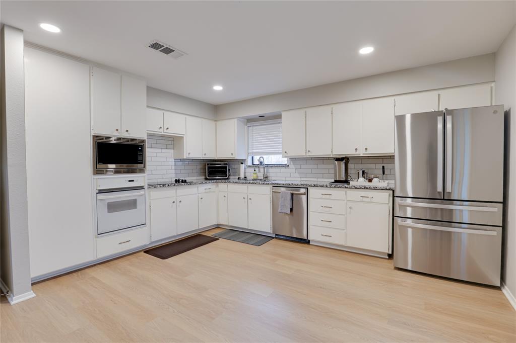 54 Legend Road Benbrook, TX 76132 - Photo 10 of 23 a kitchen with white cabinets and stainless steel appliances