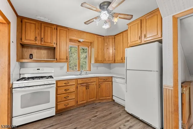 a kitchen with stainless steel appliances granite countertop a refrigerator stove a sink and dishwasher with wooden floor