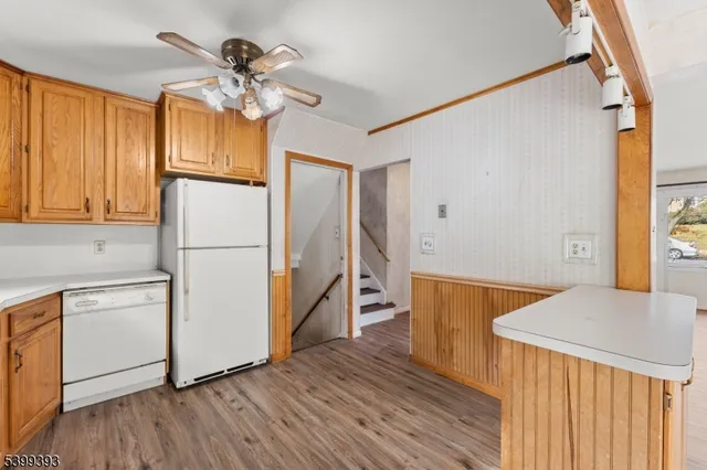 a kitchen with stainless steel appliances wooden floor and a refrigerator