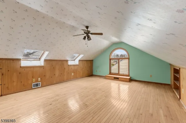 a view of a livingroom with wooden floor and a ceiling fan
