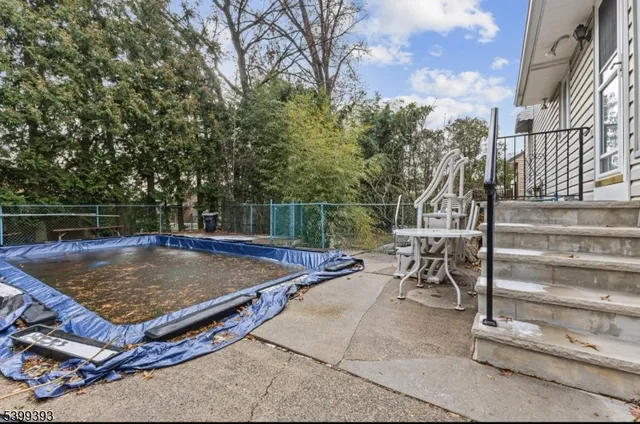 a view of a backyard with swimming pool and sitting area