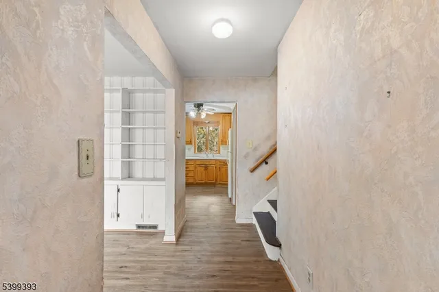 a view of a hallway with wooden floor and staircase