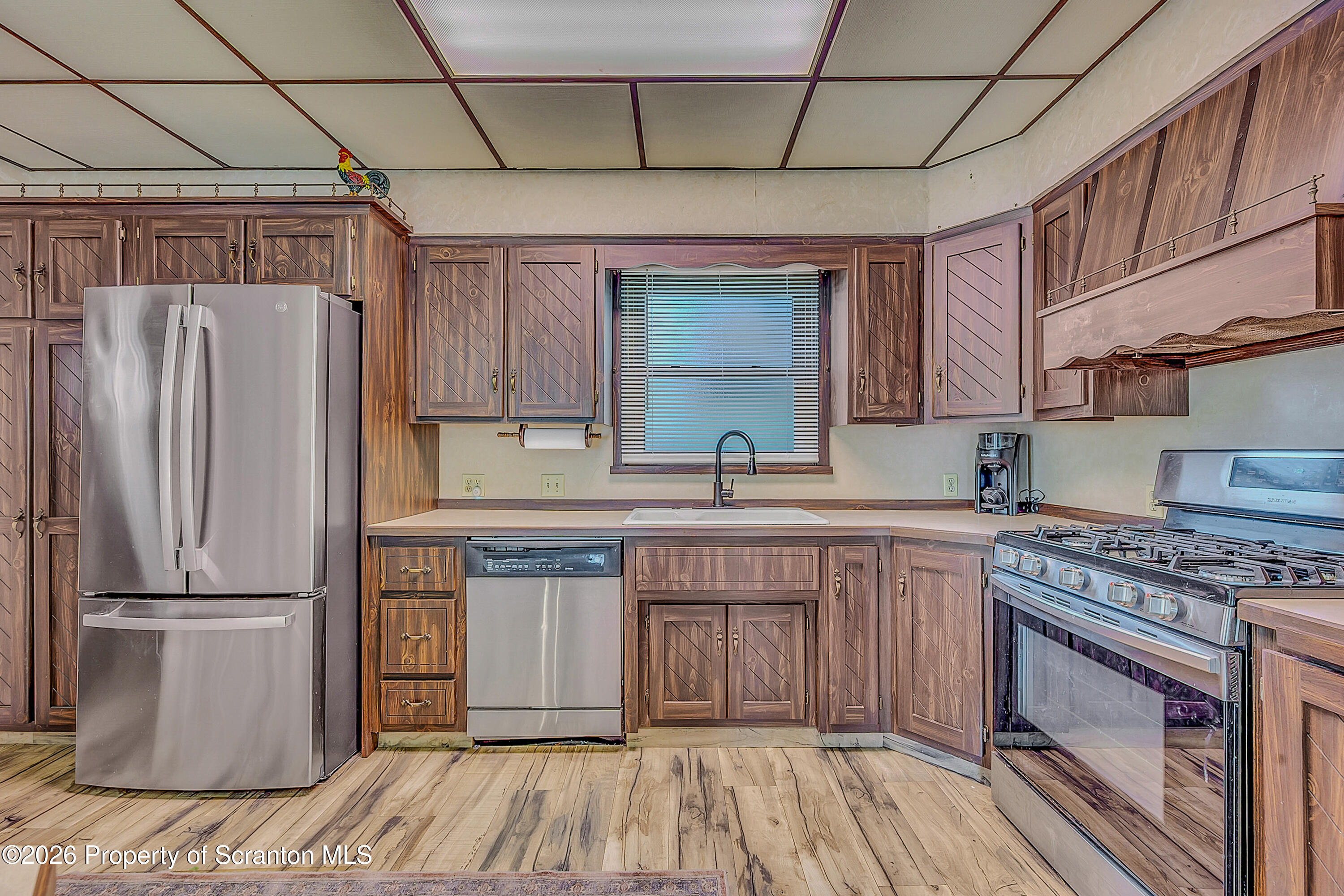 929 Ridge Avenue Scranton, PA 18510 - Photo 17 of 33 a kitchen with stainless steel appliances granite countertop a refrigerator a sink dishwasher a stove and white countertops with wooden floor