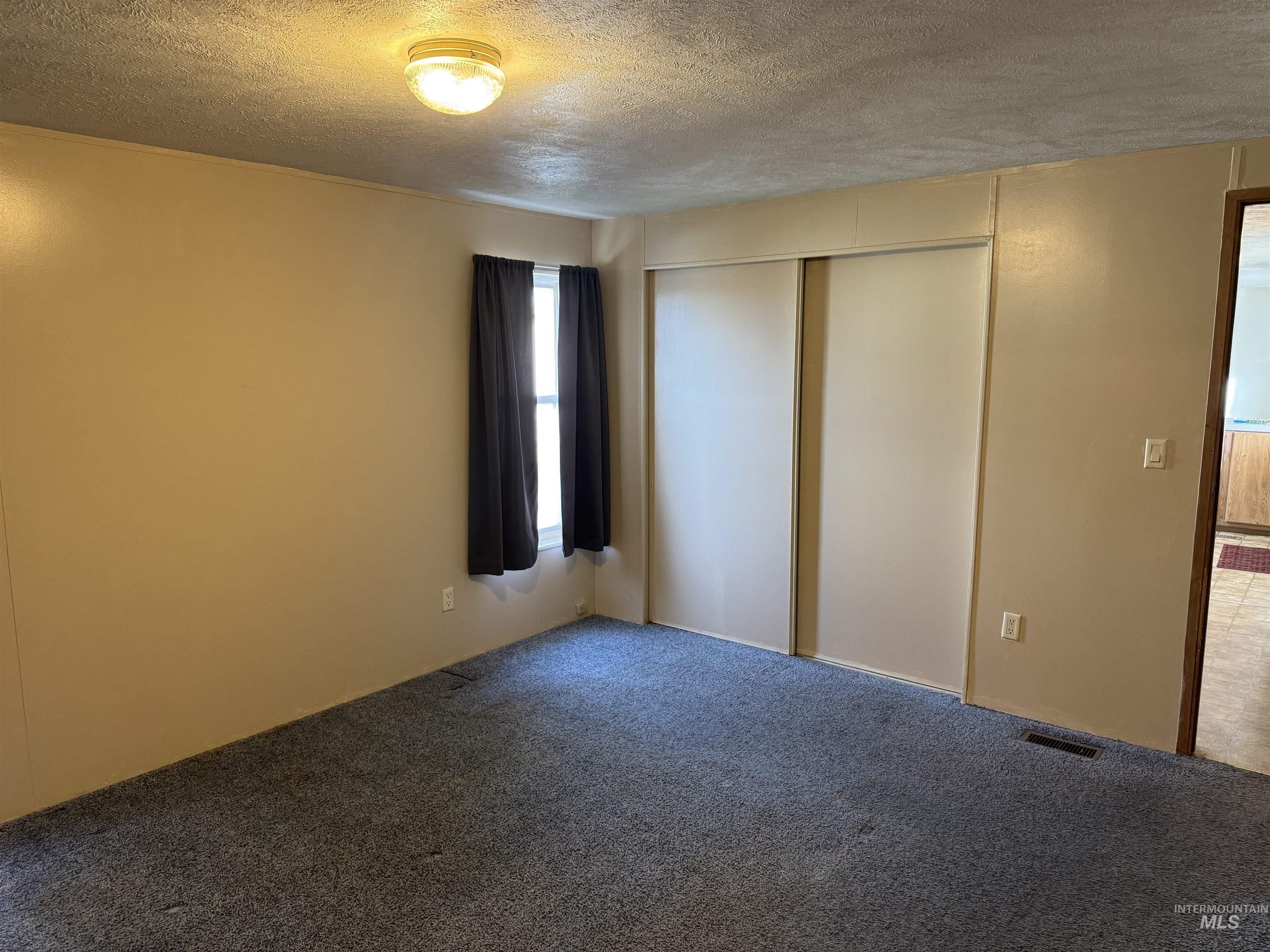 198 South Hills Road, Unit 83 Twin Falls, ID 83301 - Photo 13 of 21 Unfurnished bedroom with a textured ceiling, carpet, and a closet
