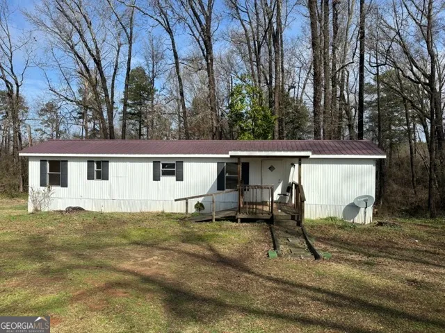 a view of a house with backyard and trees