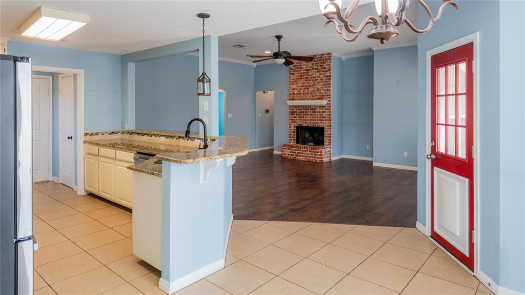 124 Topaz Circle Hewitt, TX 76643 - Photo 7 of 28 Kitchen featuring a ceiling fan, light tile patterned flooring, freestanding refrigerator, light stone counters, and a chandelier