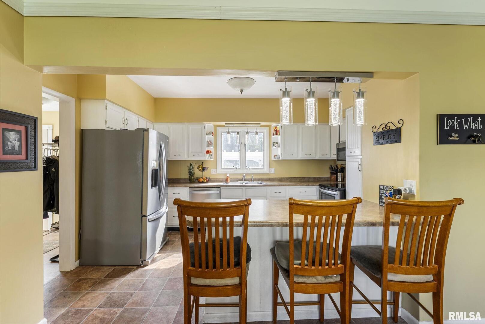 109 West 6th Street Wilton, IA 52778 - Photo 15 of 40 a dining room with stainless steel appliances a dining table and chairs