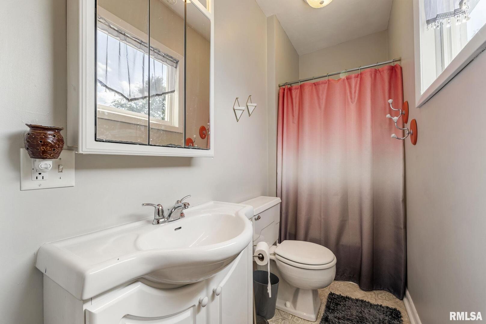 109 West 6th Street Wilton, IA 52778 - Photo 20 of 40 a bathroom with a sink a toilet and a mirror