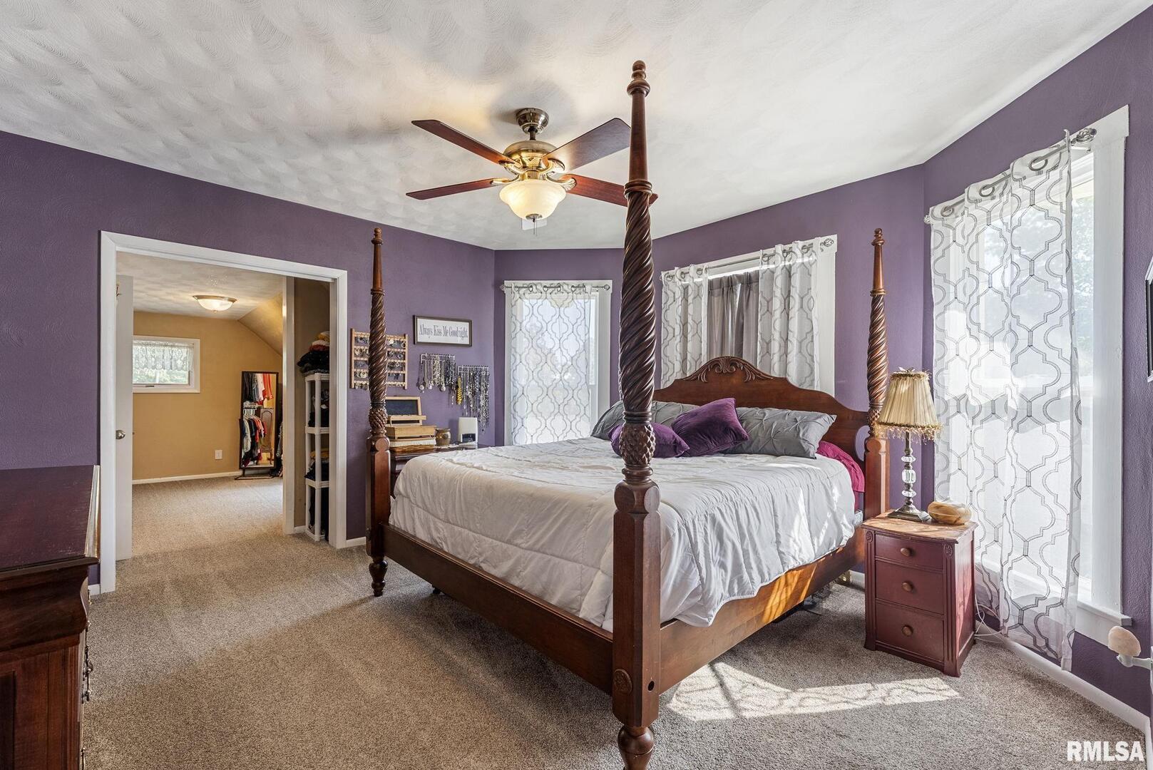 109 West 6th Street Wilton, IA 52778 - Photo 22 of 40 a bedroom with a large bed and a chandelier