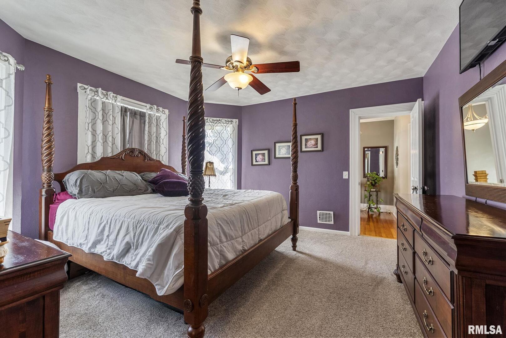 109 West 6th Street Wilton, IA 52778 - Photo 24 of 40 a bedroom with a bed a chandelier and dresser