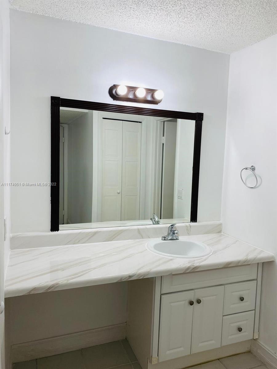 380 Racquet Club Road, Unit 103 Weston, FL 33326 - Photo 12 of 25 a bathroom with a sink and a mirror