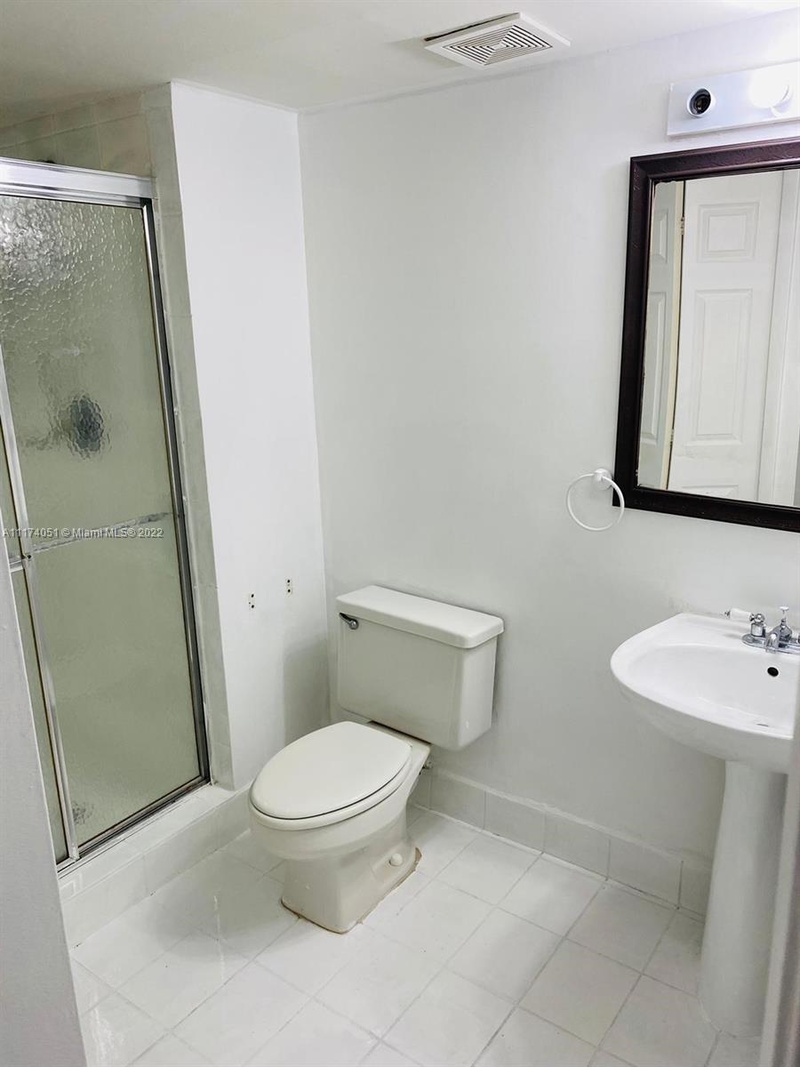 380 Racquet Club Road, Unit 103 Weston, FL 33326 - Photo 18 of 25 a bathroom with a toilet a sink and a mirror