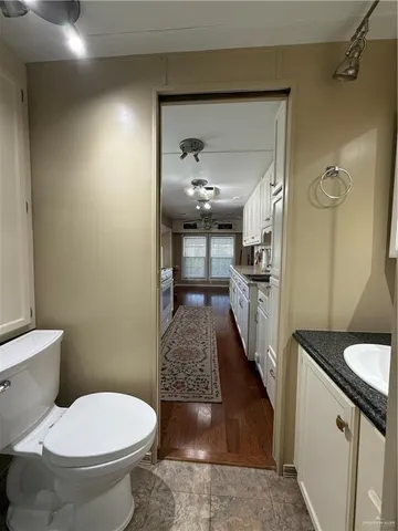a bathroom with a granite countertop toilet sink and shower