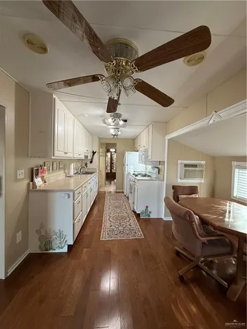 a living room with kitchen island granite countertop furniture and a wooden floor