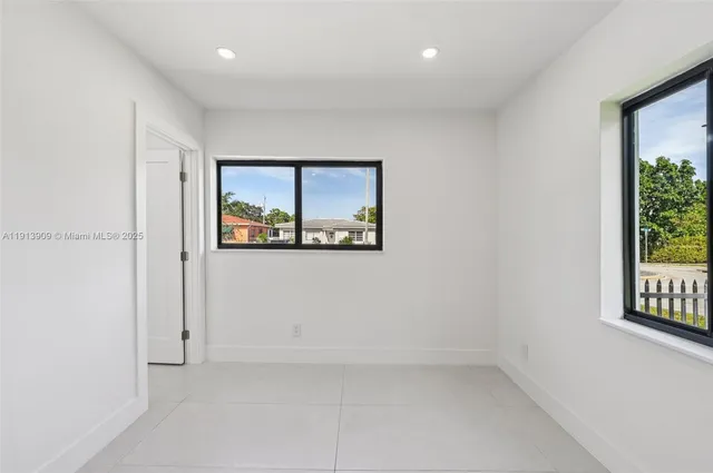 a view of an empty room with cabinet and a bathroom