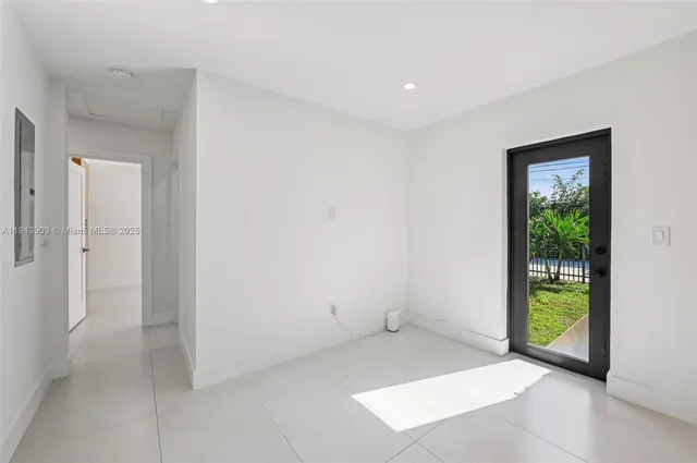 an empty room with floor to ceiling windows and garden