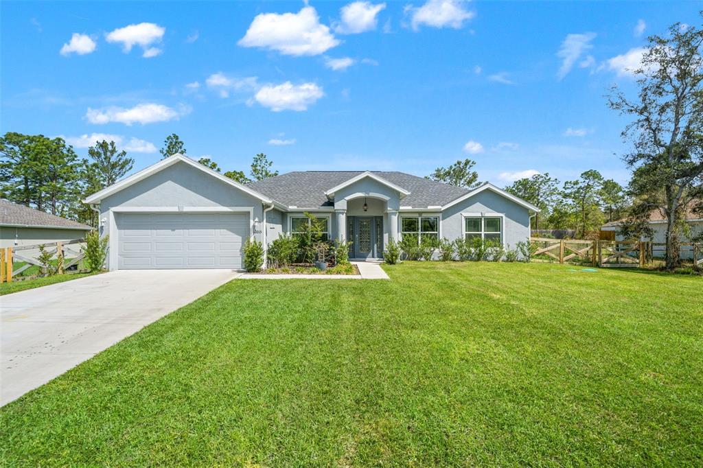 12015 Phoenix Avenue Weeki Wachee, FL 34614 - Photo 1 of 39 a front view of house with yard and green space